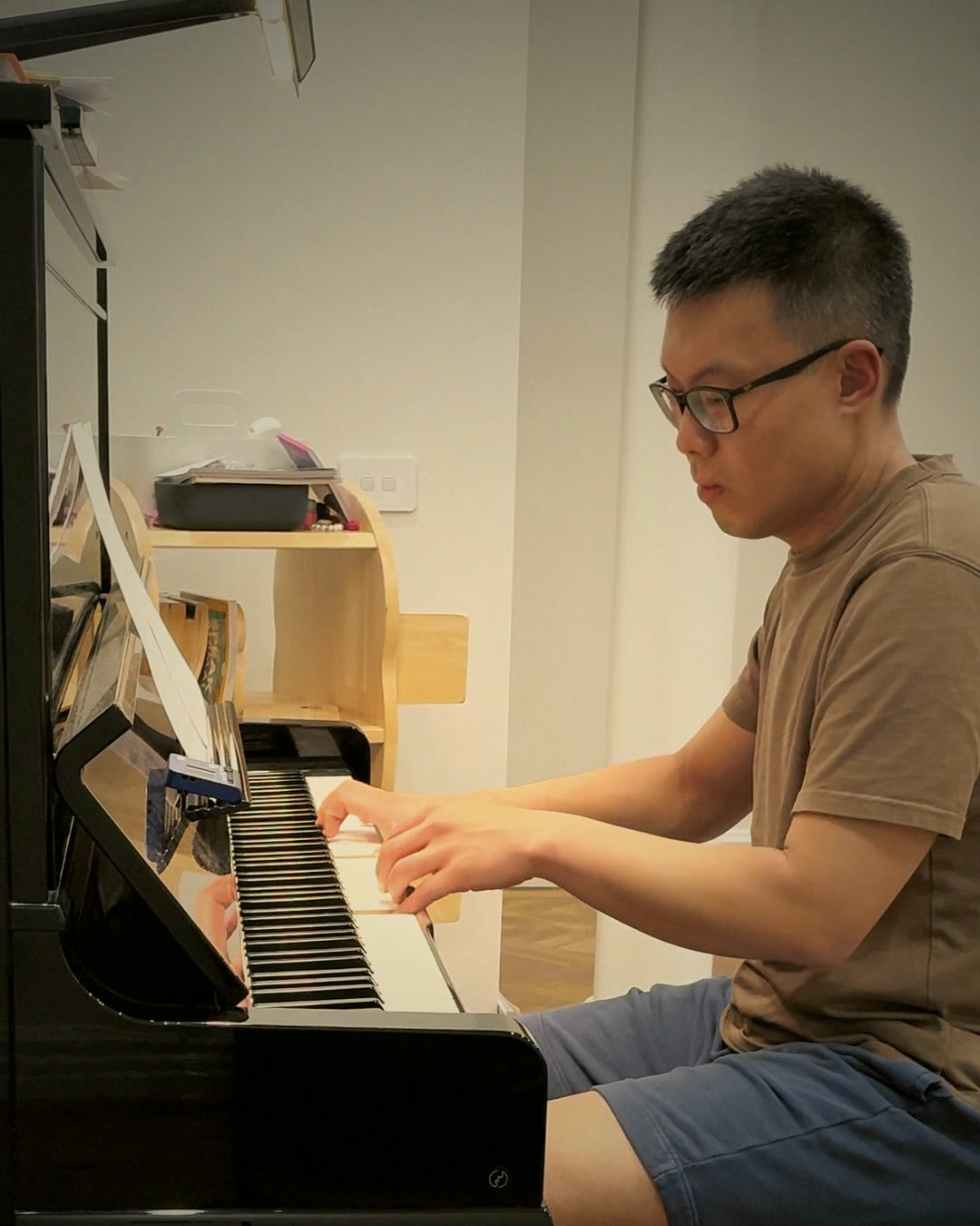 Hao at the upright piano at home